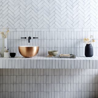 white tiles with tiled shelf and gold basin