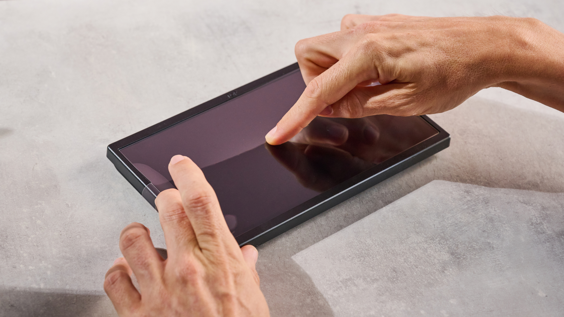 A man pushing bubbles out from under the Belkin Tempered Glass Anti-Reflective Screen Protector once it has been applied to the Nintendo Switch 2.