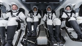 A photo of four astronauts in a space shuttle