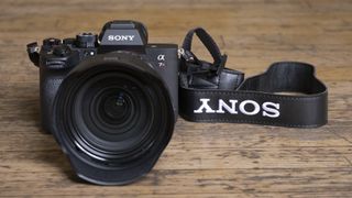 The Sony A7R V camera sitting on a wooden floor