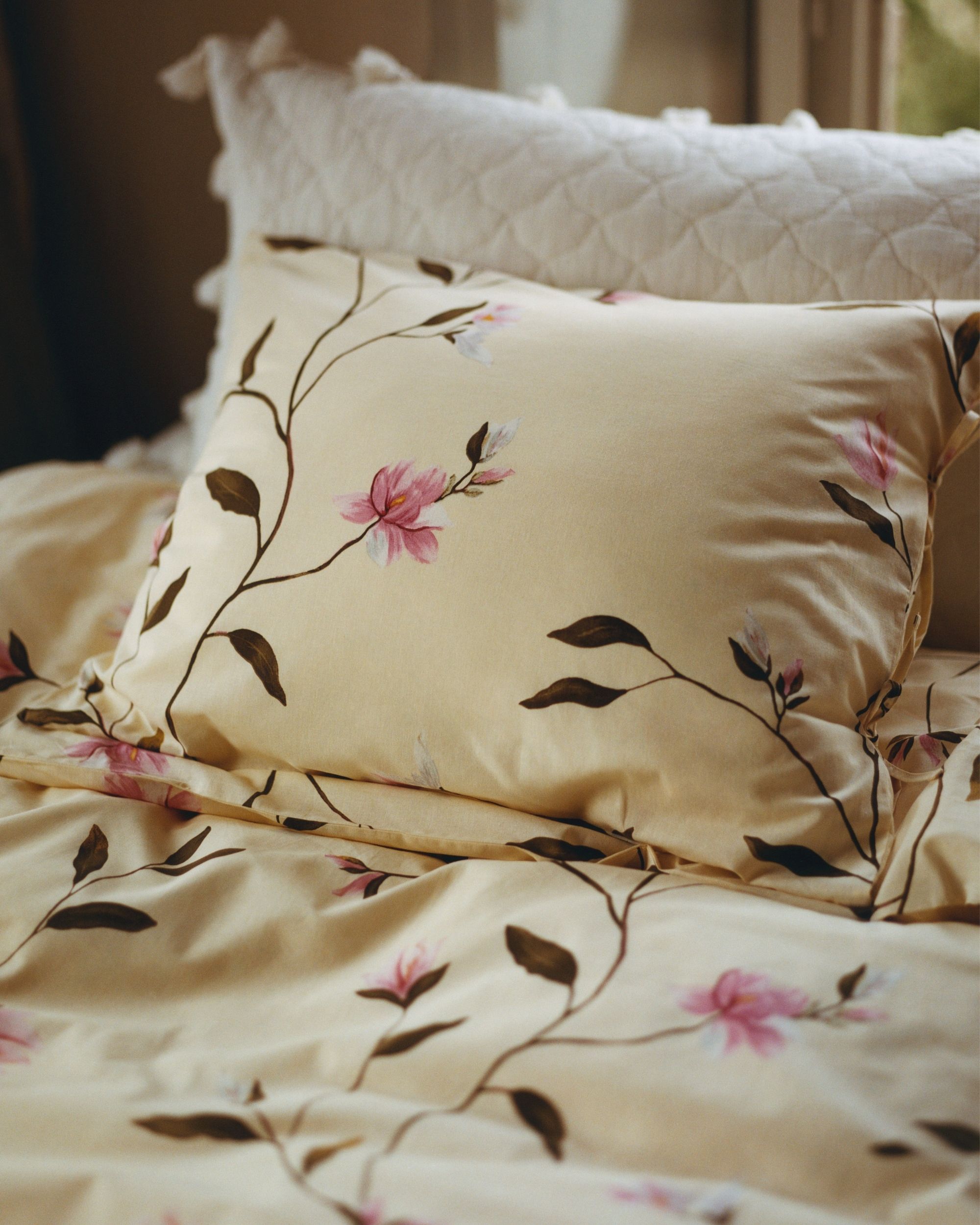 Close-up image of butter yellow bedding with a delicate floral pattern.