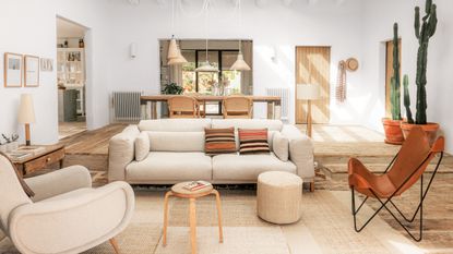 neutral living room with vintage furniture, white sofa, mid century modern curved armchair, striped cushions and leather butterfly chair