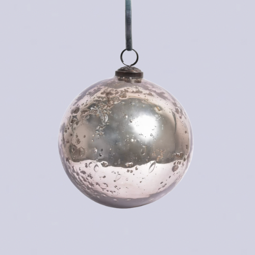 A silver dented bauble on a light blue velvet ribbon