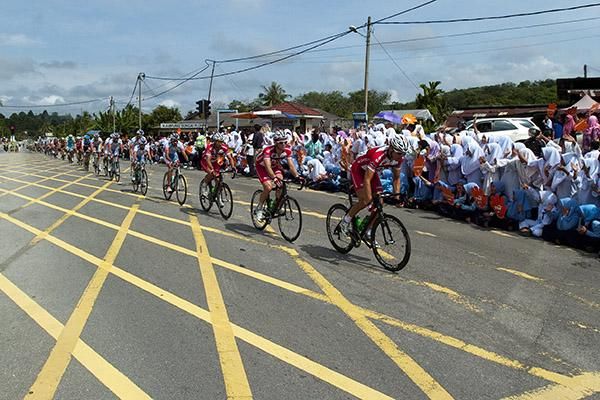 The peloton pass by some keen locals on the outskirts of Kuala Lumpur.