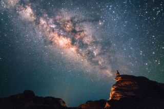 Silhouette of a man looking at the Milky Way Stars shining above the Grand Canyon of Thailand (Sam Phan Bok)