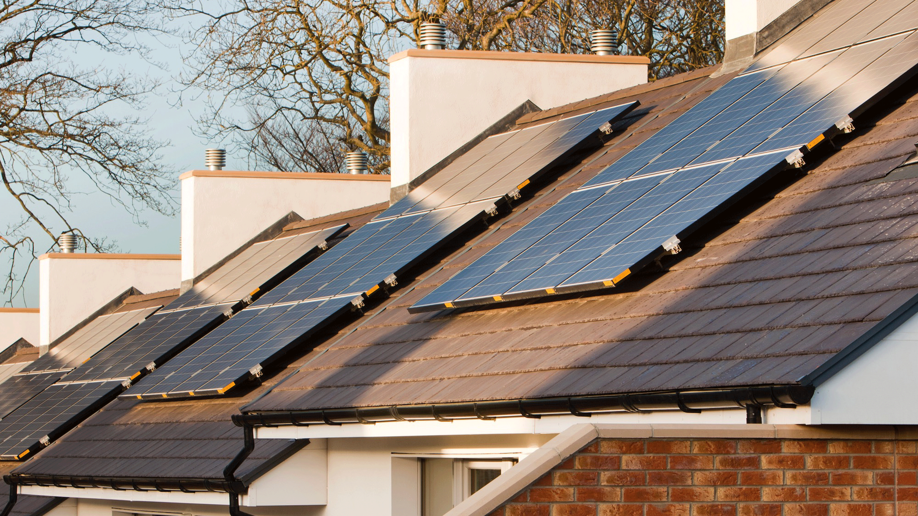 exterior of house with photovoltaic panels and wooden gate