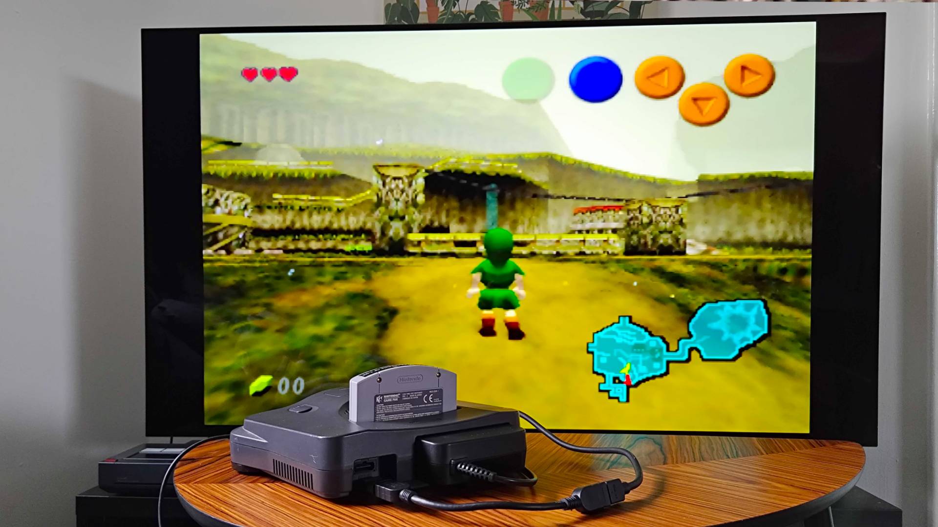 Back view of N64 with HDMI mod and cable connected to LG OLED C4 TV in backdrop with Zelda: Ocarina of Time gameplay on screen.