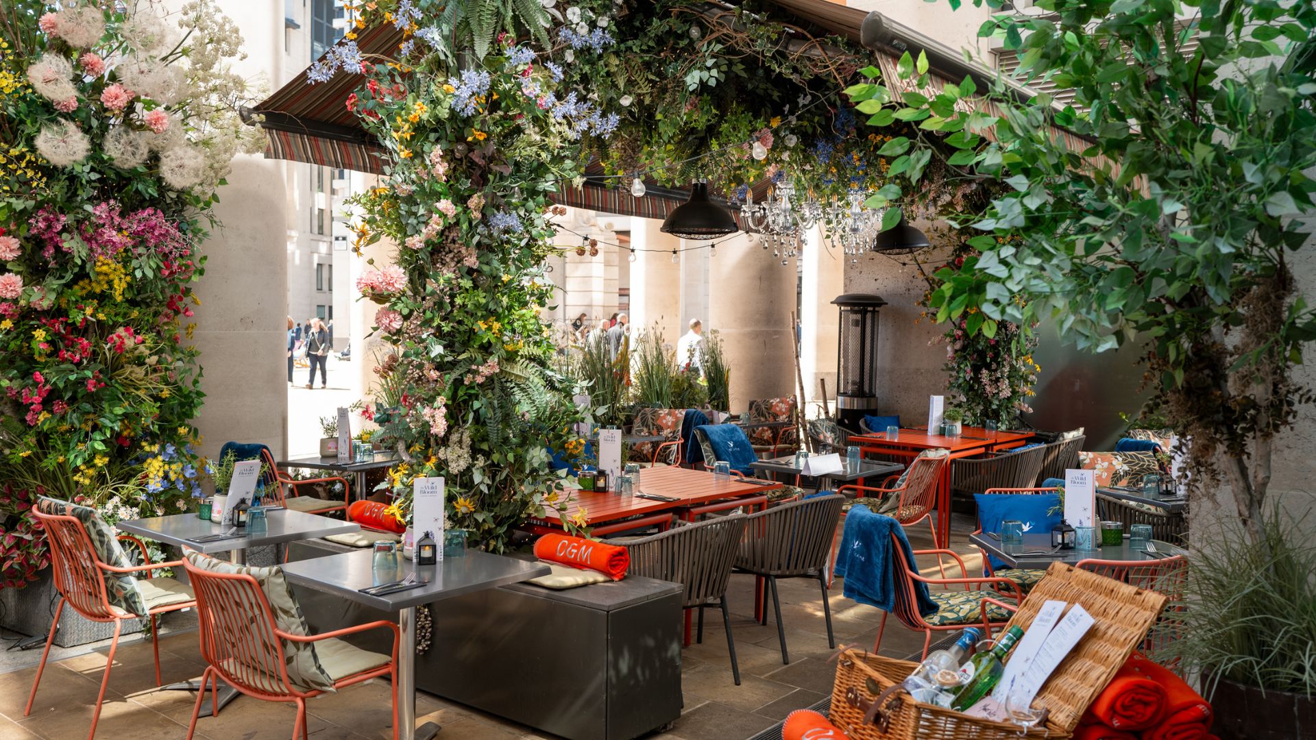 an image of the flower covered terrace at The Happenstance with tables and blankets