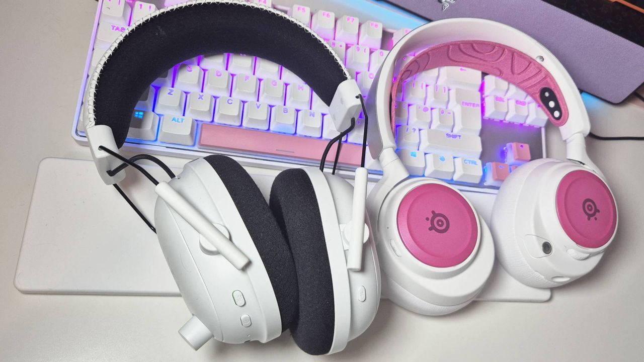 Photo of the Razer BlackShark V2 Pro and the SteelSeries Arctis Nova Pro Wireless gaming headsets sitting on a white desk, taken by writer Rosalie Newcombe.