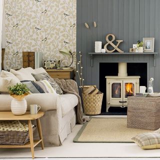 living area with wallpaper wall and grey fireplace and sofa and cushions