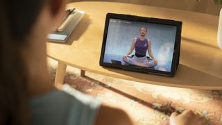 Woman looking at a tablet displaying a Peloton meditation workout