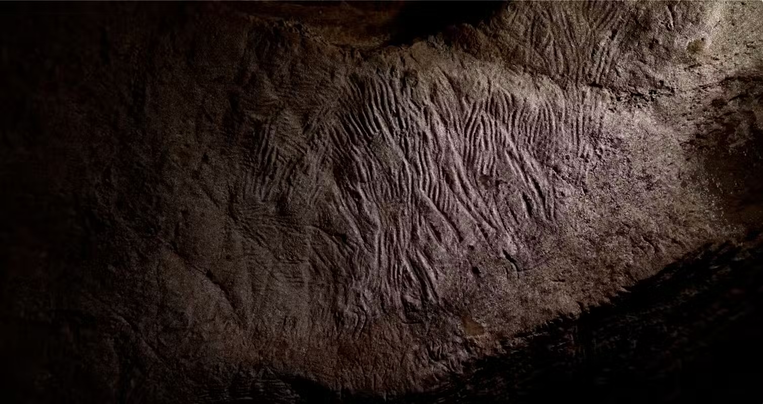 A cave ceiling with lines drawn from human fingers