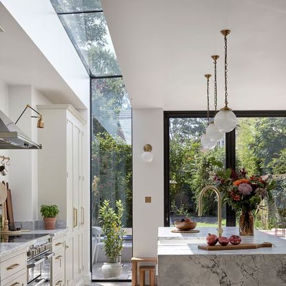 marble kitchen island and white kitchen units with up-and-over glazing