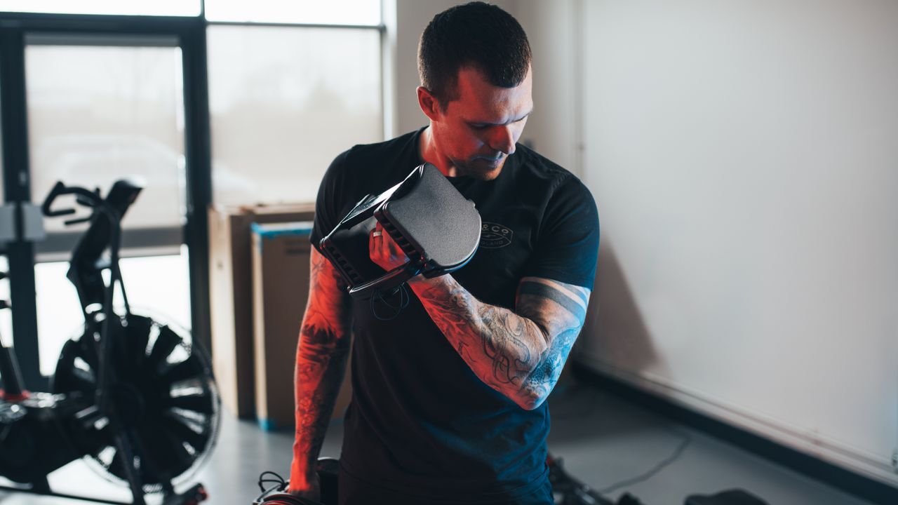 PowerBlock Sport 24 Review: Pictured here, a fit man lifting the dumbbells in a home gym