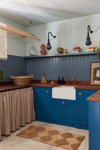 blue shaker kitchen with paneling and gingham skirt