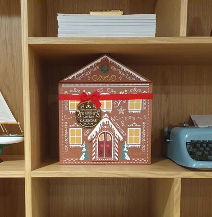 The Aldi scented candle advent calendar on a styled bookshelf