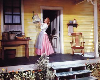 a woman sings on the porch of her yellow farm house in the movie Oklahoma