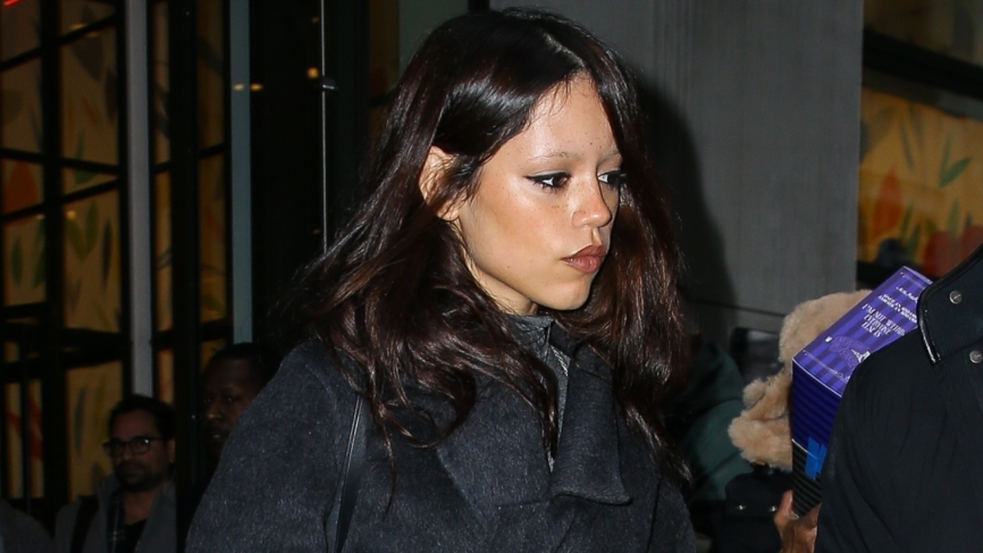 Jenna Ortega tests Fall 2025&#039;s cuffed jeans trend with a wool wrap coat and leather gloves in NYC