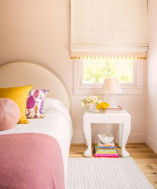 Pink bedroom, yellow cushion, white bedside table