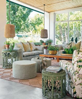 verandah with reed ceiling and netural and floral print sofas and cushions