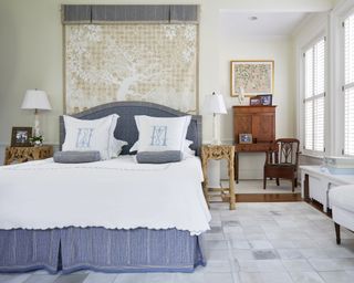 A master bedroom with tapestry hung over a blue bed