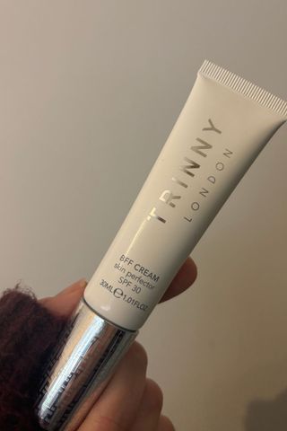 a hand holding trinny london bff cream