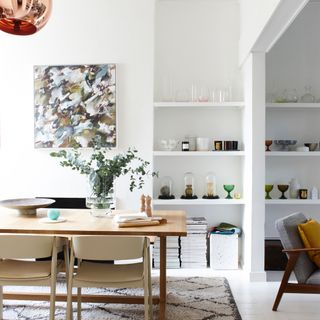 Broken plan living dining space with open shelving for books and glassware