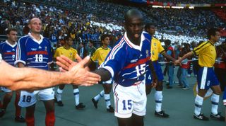 12 July 1998 - FIFA World Cup - Final - Stade de France - Brazil v France - Lilian Thuram of France high-fives a fan whilst walking out the the pitch. - (photo by Mark Leech/Offside/Getty Images)