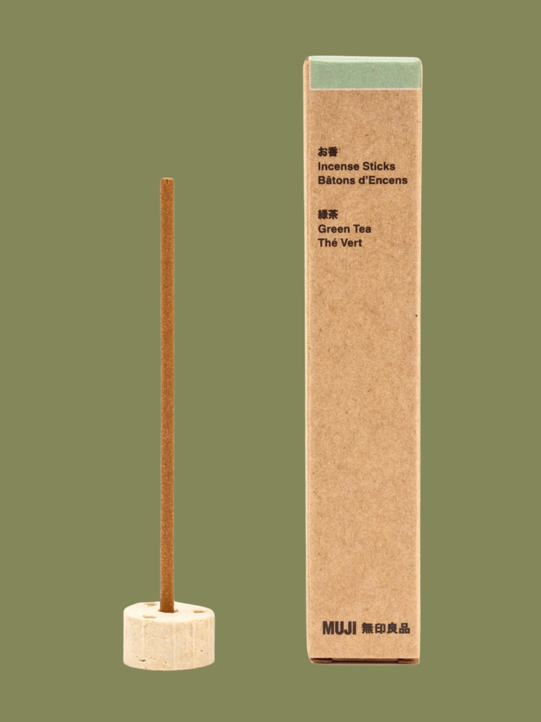 A green tea incense stick in a holder from MUJI