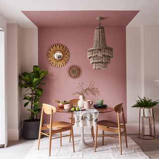 dining area with chandelier and painted pink ceiling with dining table and chairs