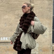 Elsa wears a fur-trimmed coat with a brown gucci bag.
