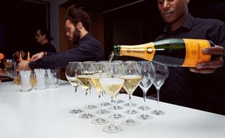 Waiter pouring Veuve Clicquot Champagne into wine glasses