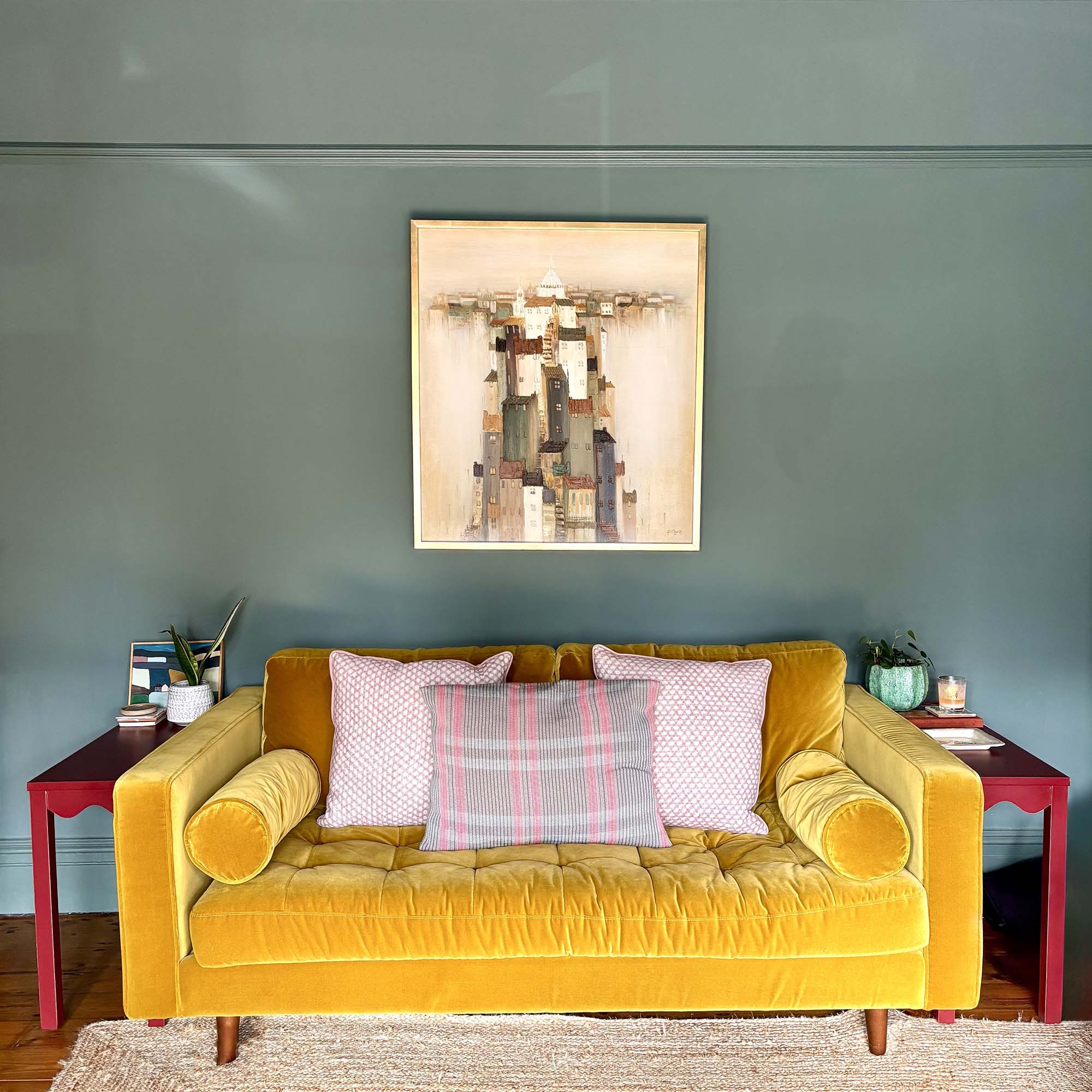 yellow sofa below a piece of modern art framed on the wall
