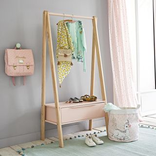 bedroom with wooden clothes hanger and pink drawer