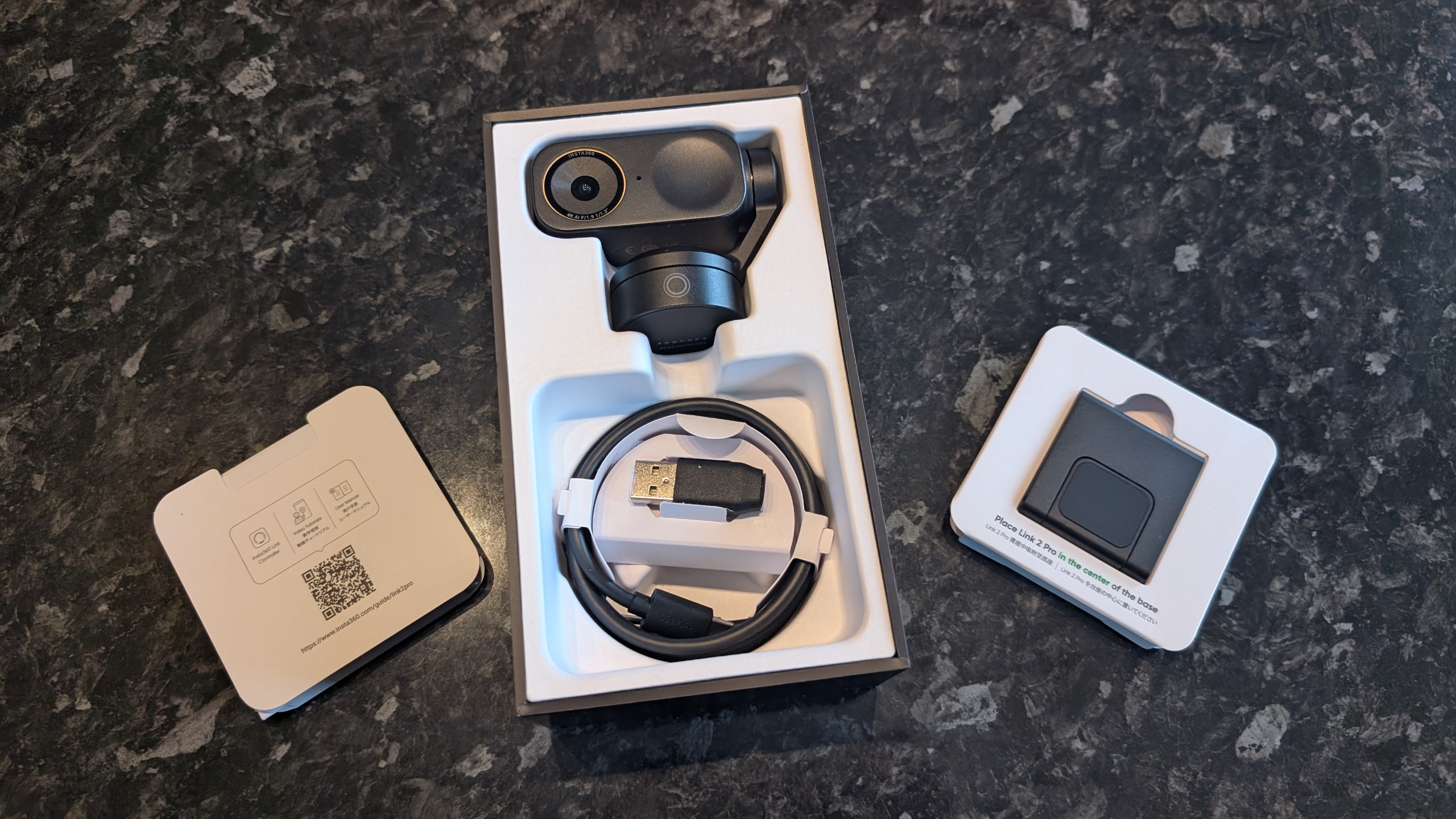 The Insta360 Link 2 Pro webcam, pictured on a marble worktop.