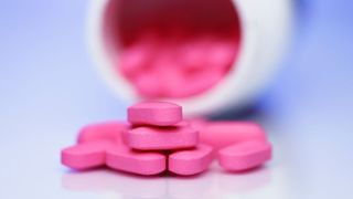 benadryl tablets spilled on a table in front of a pill bottle