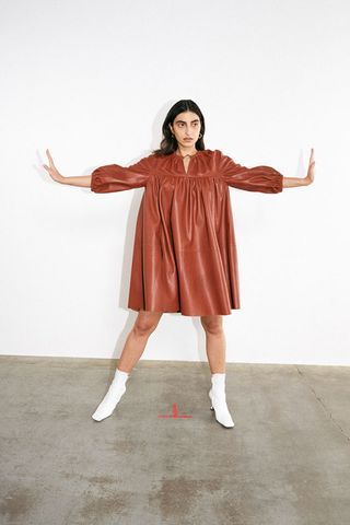 Model wears Aeron Pre-Fall 2021 smocked chestnut leather dress