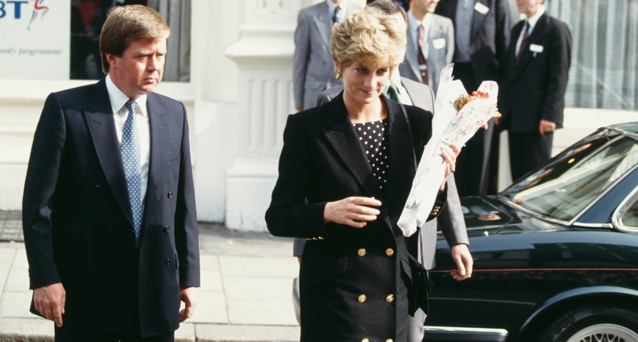 Princess Diana wearing a black blazer walking next to bodyguard Ken Wharfe