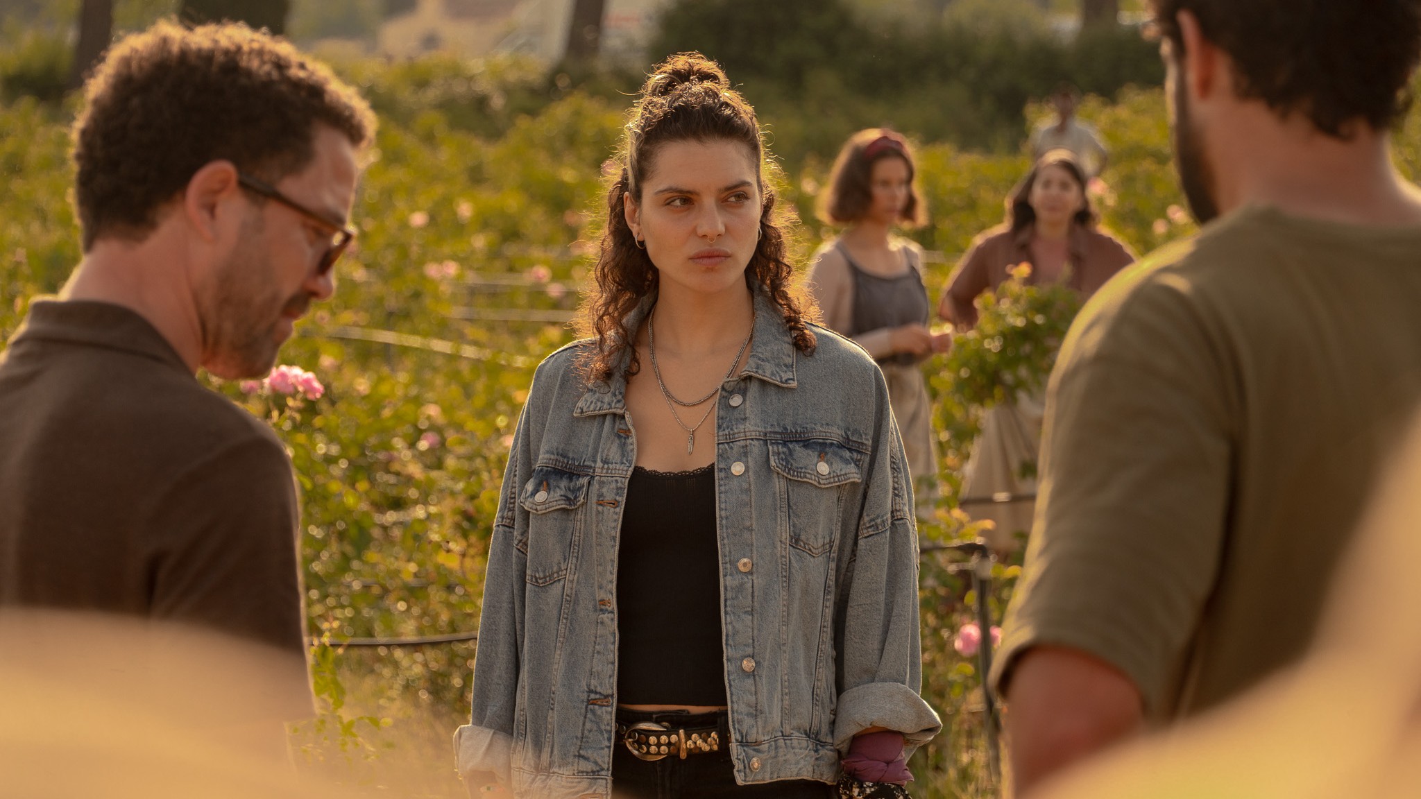 A still featuring members of the "Under a Dark Sun" cast standing in a field in the Netflix thriller