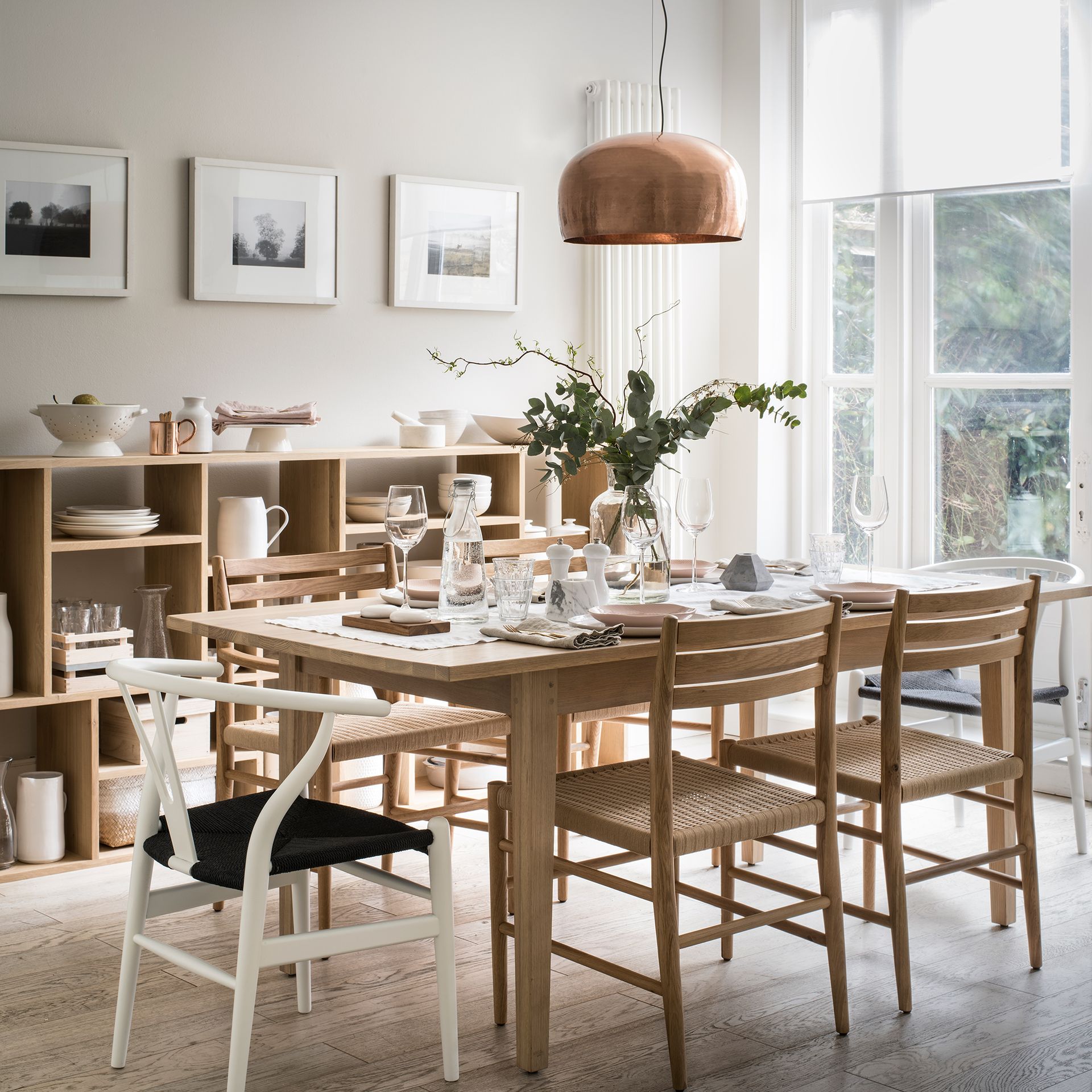 Neutral dining room with wooden furniture and metallic pendant