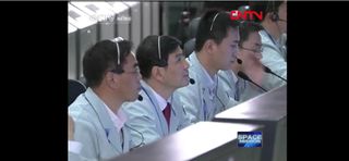 Chinese Mission Controllers watch as the Tiangong 1 spacecraft makes the country's first docking maneuver with Shenzhou 8.