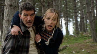 A still from the movie Black Butterfly showing Antonio Banderas as Paul Lopez and Piper Perabo as Laura Johnson looking distressed in the woods