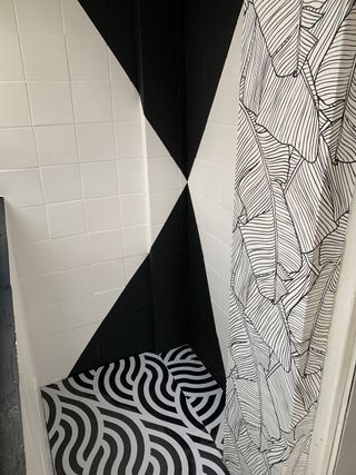 Painted tiles in white and black with pattern wallpaper in tiny porch space