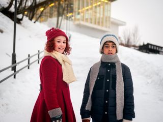 a little girl in a red coat and a boy in a blue coat standing outside in the snow in the movie the snow sister