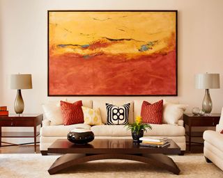 Living room with earthy color pops and supersized feature artwork