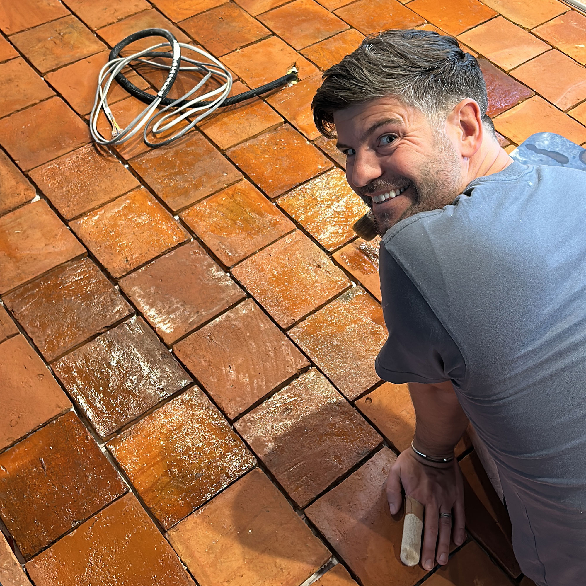 Man treating terracotta tiled floors