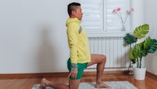 Man performs hip flexor stretch at home