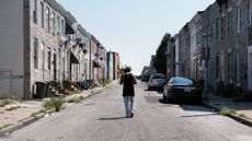 A man walks down a dilapidated street in Baltimore in 2019.