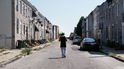 A man walks down a dilapidated street in Baltimore in 2019. 