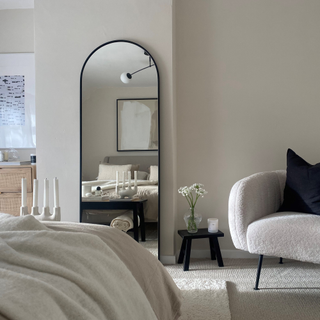 bedroom with white wall and mirror